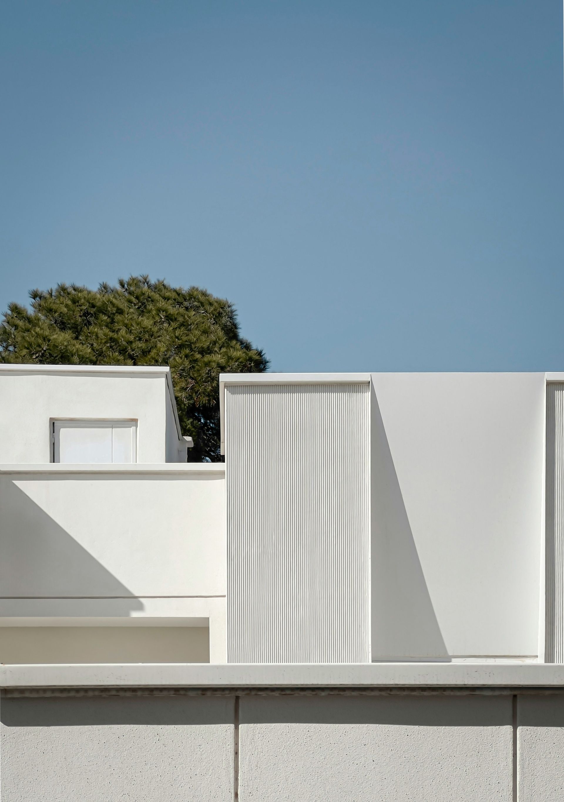 a white building with a tree in the background